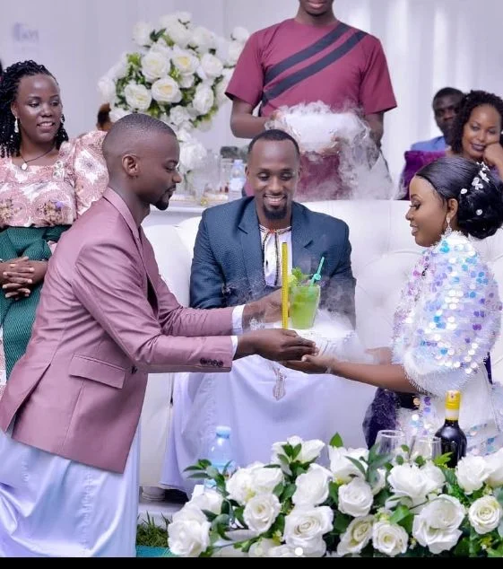 A server presenting a smoky juice toast to a celebrating couple