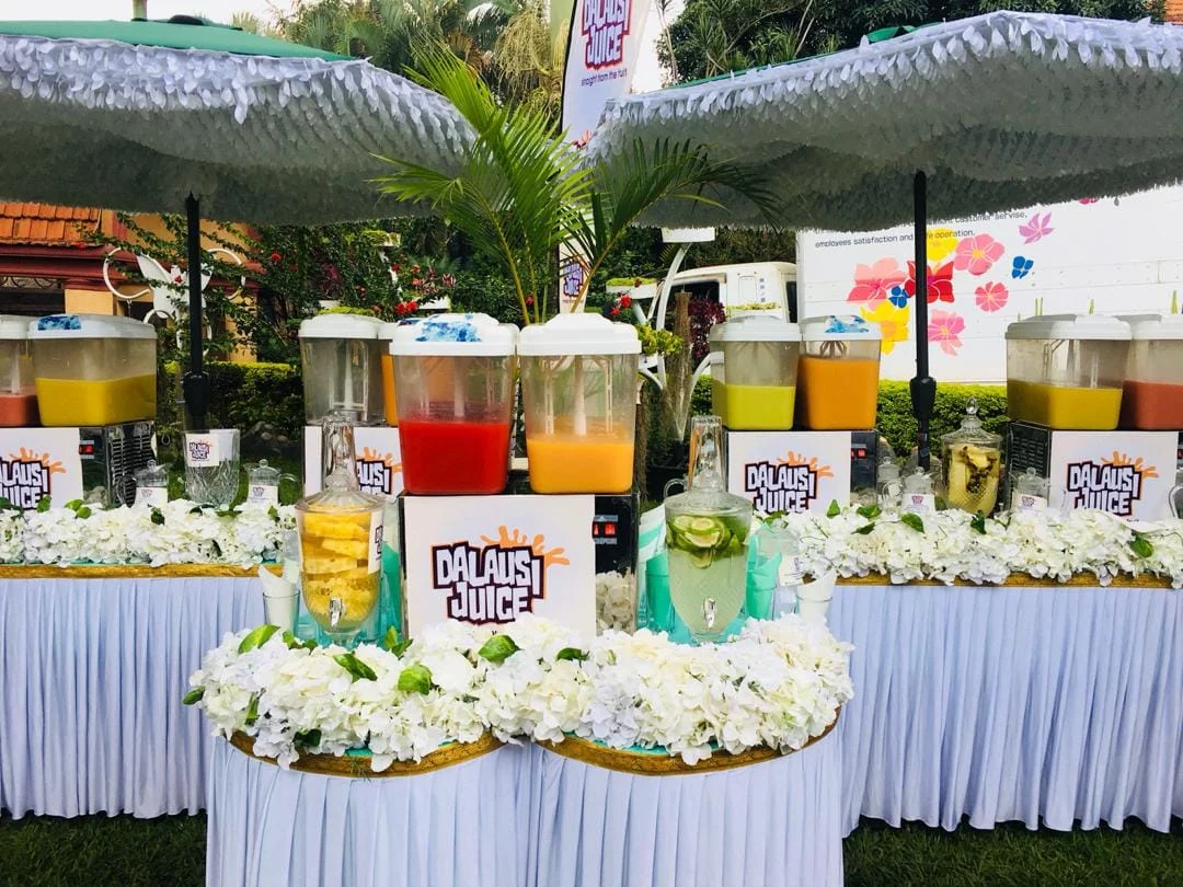Dalausi’s outdoor juice station with white flowers, colourful juices and fruit-infused drinks